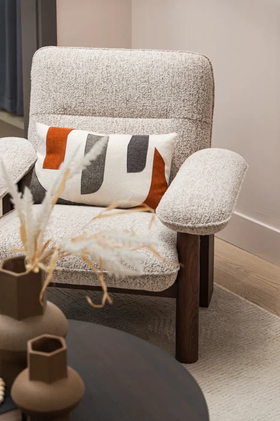Bouclé armchair detail with accent cushion